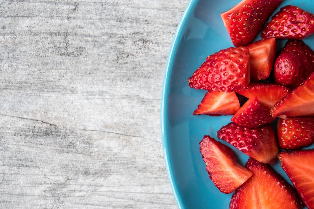 Sliced strawberries on teal ceramic plate from Jessica Lewis 🦋 thepaintedsquare on Unsplash Bệnh đau vú khi sinh nở hoặc khi có kinh kỳ