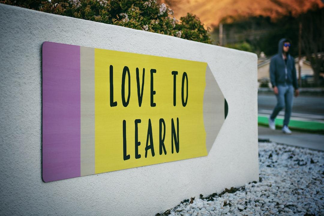 Love to learn pencil signage on wall near walking man from Tim Mossholder on Unsplash