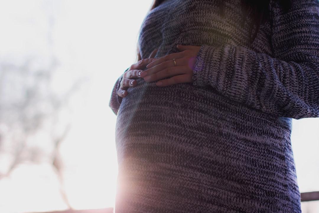 Woman holding her prenant tummy during daytime from freestocks on Unsplash