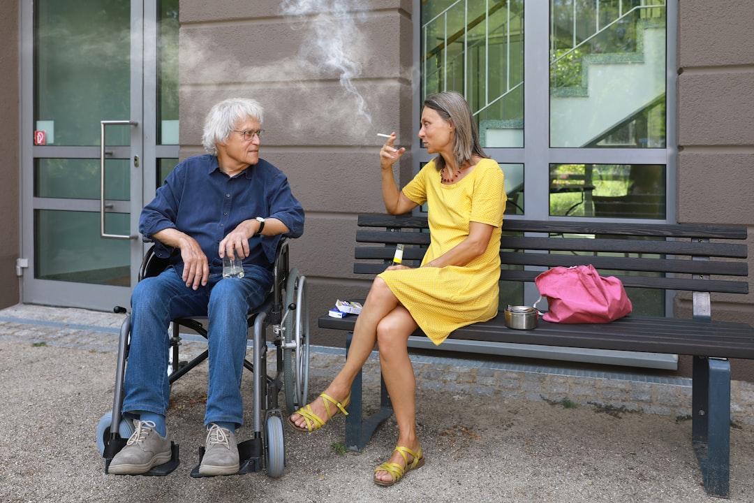 A man sitting on a bench next to a woman smoking a cigarette from Ernst-Günther Krause (NID) on Unsplash Aspirin chỉ có lợi cho nam giới