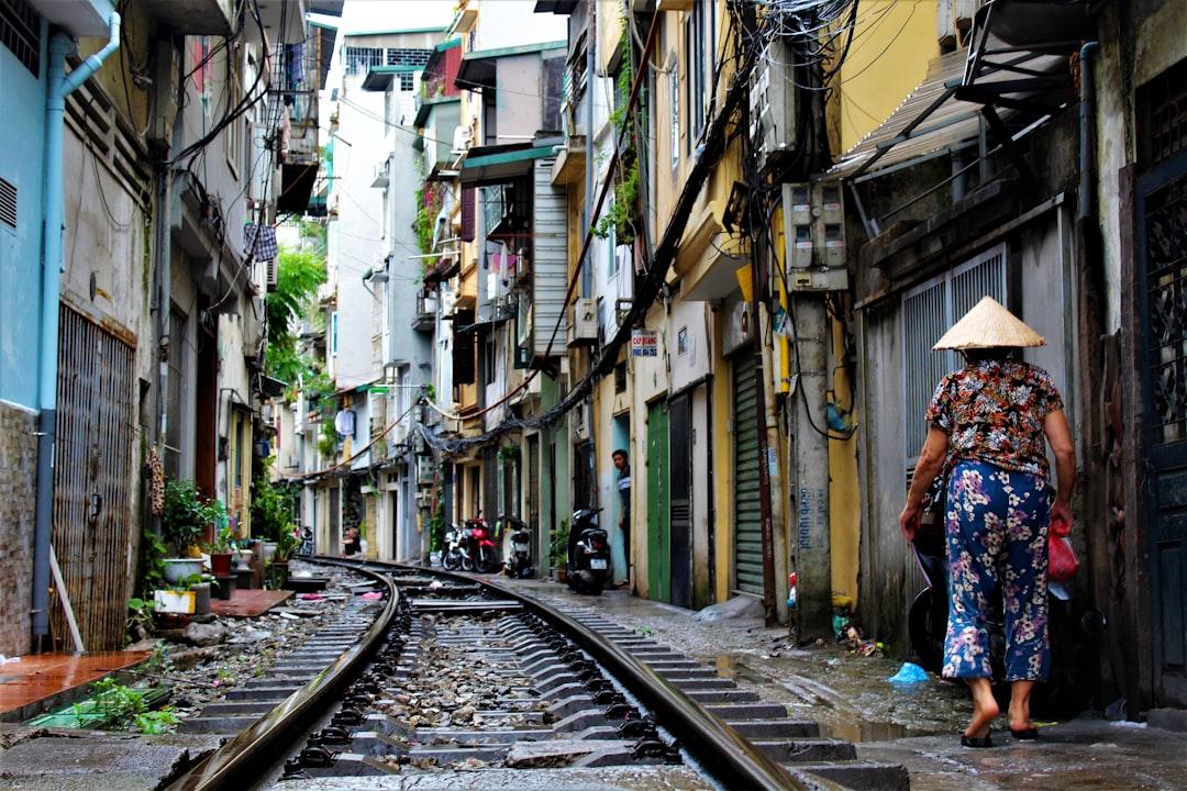 Person walking on railway side between buildings at daytime from Thijs Degenkamp on Unsplash