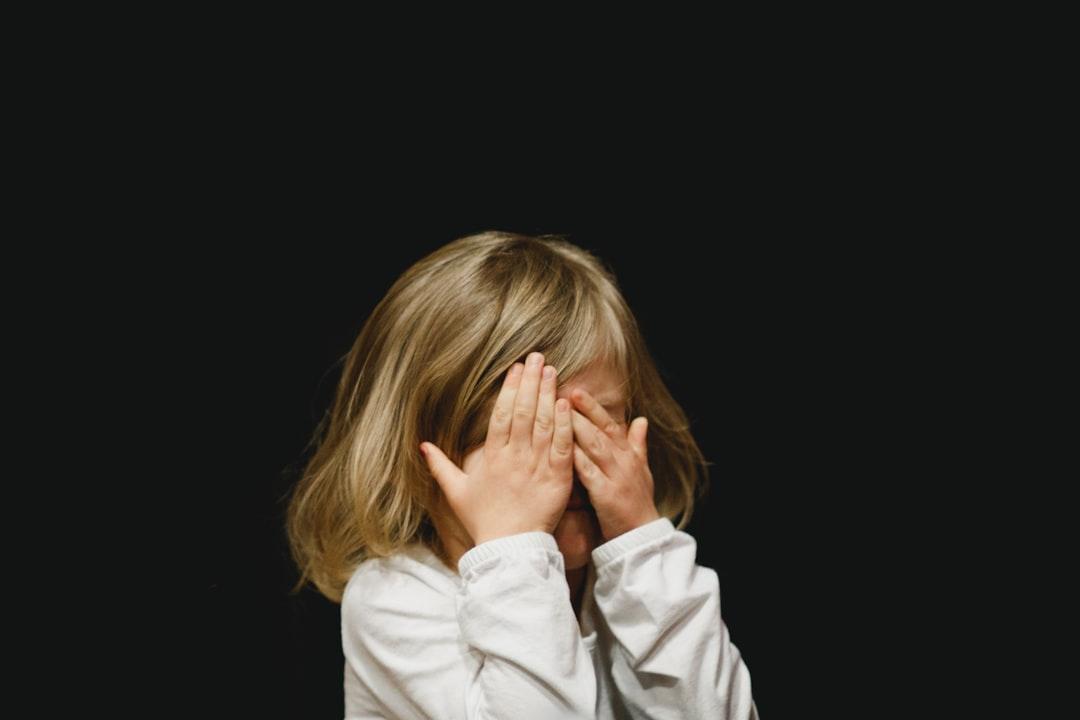 Girl covering her face with both hands from Caleb Woods on Unsplash