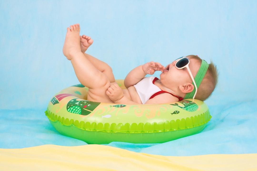 Baby lying on inflatable ring from Valeria Zoncoll on Unsplash Ôm ấp giúp trẻ bớt đau