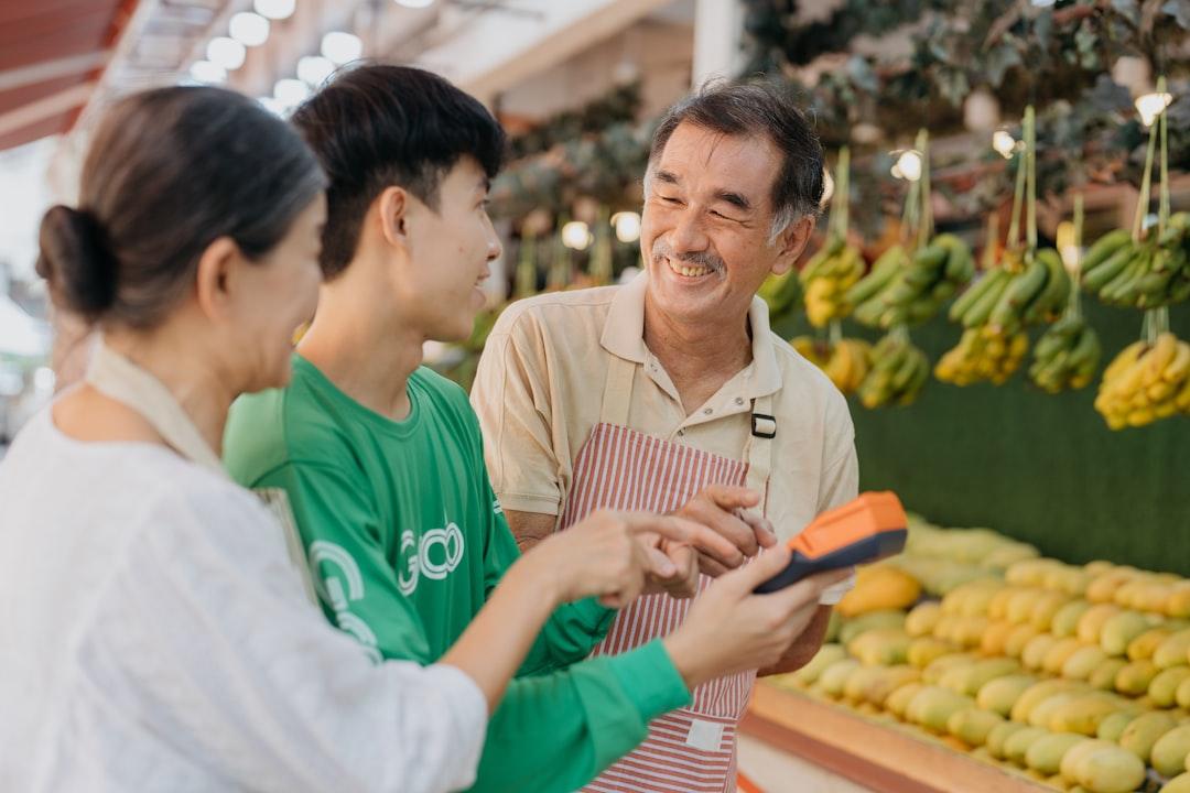 A couple of people standing in front of a fruit stand from Grab on Unsplash