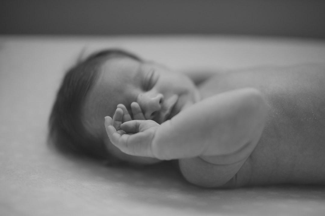Grayscale photo of baby from Jenna Norman on Unsplash Chăm sóc giấc ngủ của bé