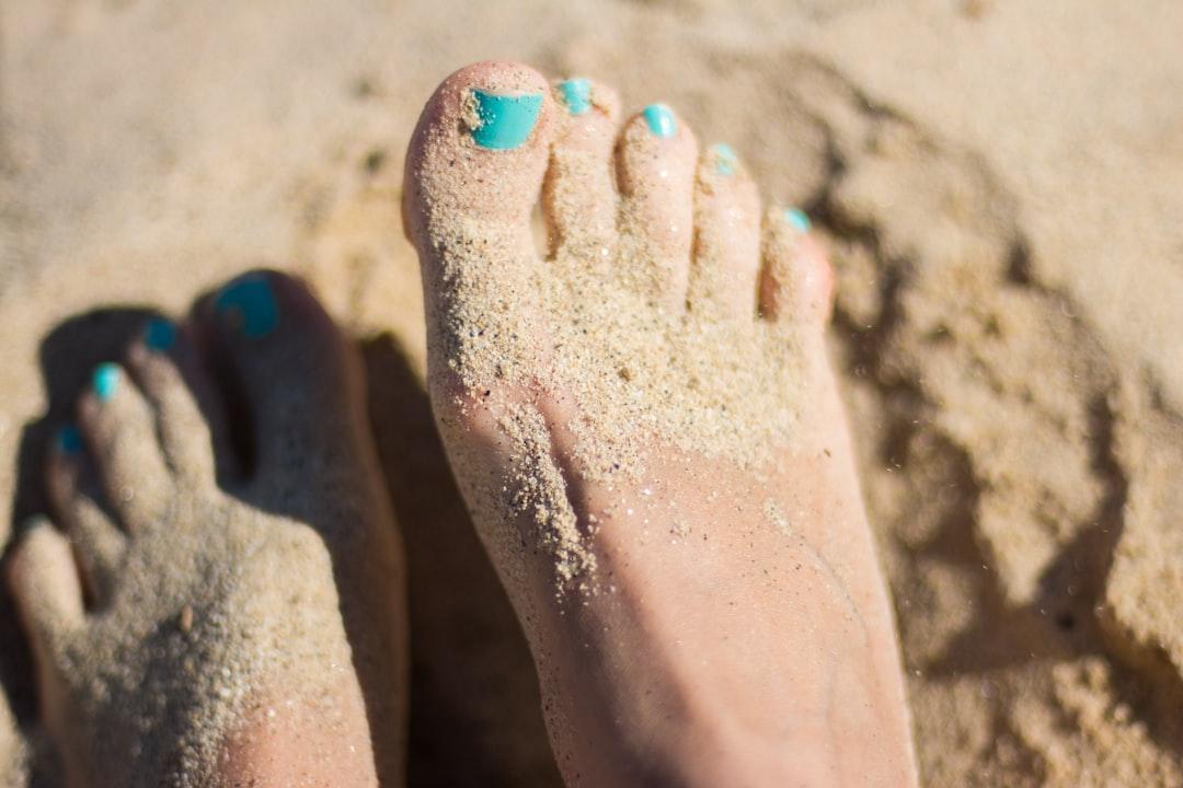 Person sky-blue nail polish feet on brown sand from Juja Han on Unsplash