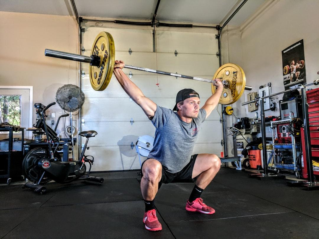 Man lifting yellow barbell from Sam Sabourin on Unsplash Tập thể dục để hạn chế ung thư vú