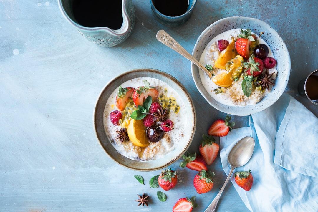 Two bowls of oatmeal with fruits from Brooke Lark on Unsplash