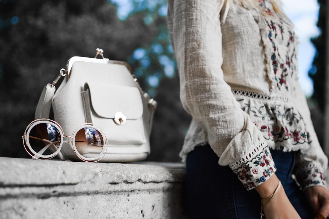 Woman wearing beige and red floral top leaning on gray concrete slab with white leather bag ontop from Tamara Bellis on Unsplash 50-60% người cao tuổi Việt Nam bị viêm xương khớp