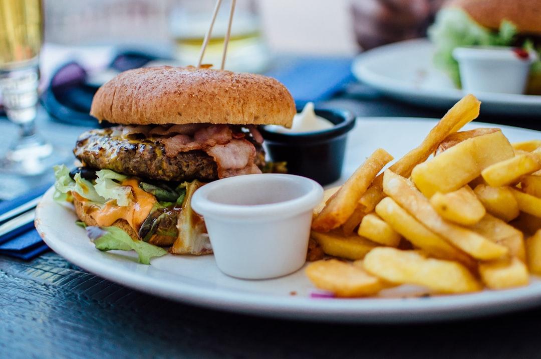 selective focus photography of burger patty, mayonnaise, and French fries served on platter Phân loại Âm Dương