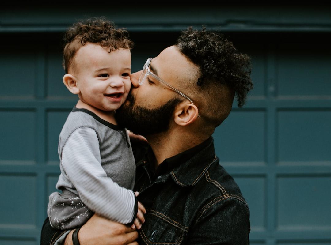Man carrying baby boy and kissing on cheek from Kelly Sikkema on Unsplash Quảng  Nam: Bùng phát dịch sốt phát ban
