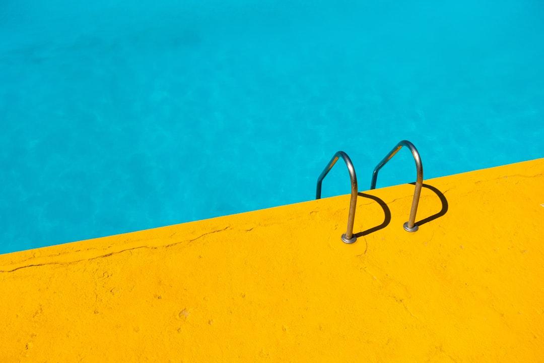 Swimming pool with stainless steel ladder from Etienne Girardet on Unsplash Hỏa Khí