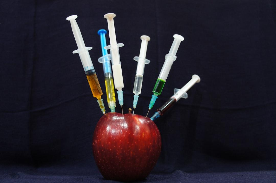 Apple fruit with plastic syringes from Sara Bakhshi on Unsplash