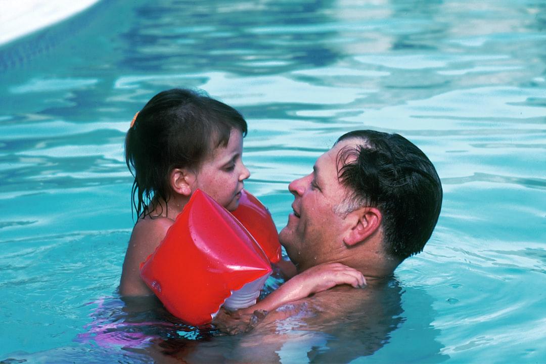 Man with toddler girl in swimming pool from National Cancer Institute on Unsplash Tiêm vắc xin Cervarix: Chưa có bằng chứng hiệu quả với người trên 25 tuổi