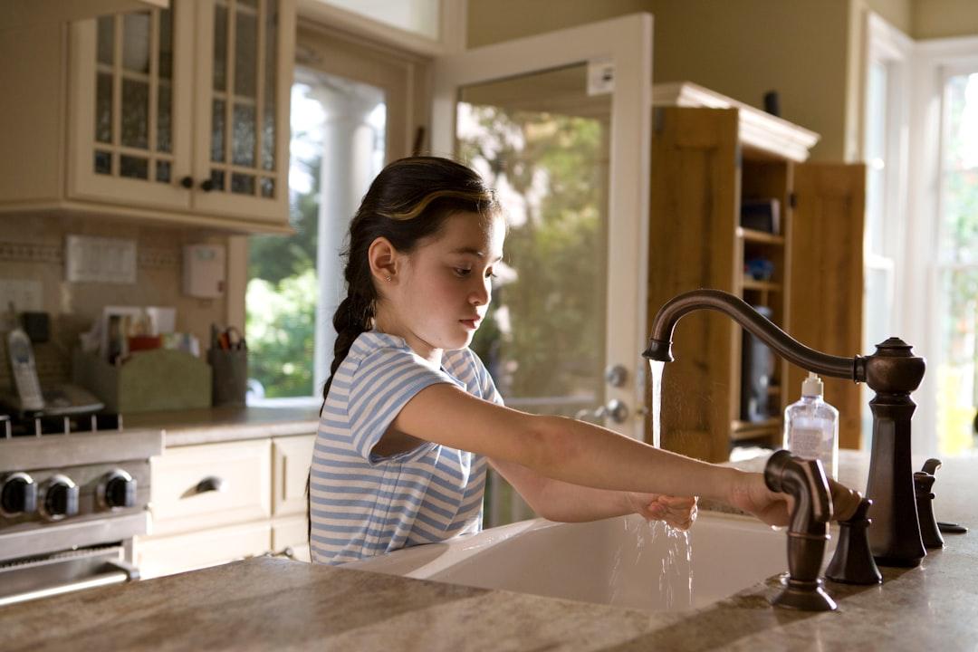 Woman in blue and white stripe shirt washing her hands from CDC on Unsplash Đề phòng rối loạn tiêu hóa trong ngày Tết