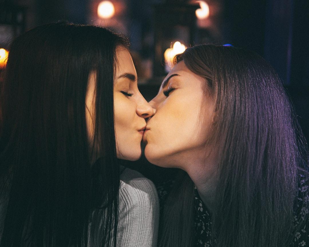 Two women kissing each other in a dark room from V T on Unsplash Bí ẩn đôi má xuân