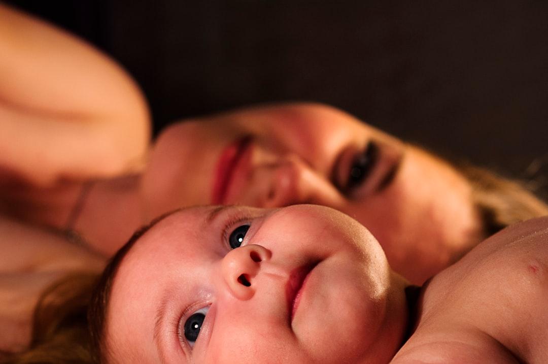 Shallow focus photography of baby beside woman from Oleg Sergeichik on Unsplash Trung Quốc thu hồi sữa tắm trẻ em Johnson & Johnson