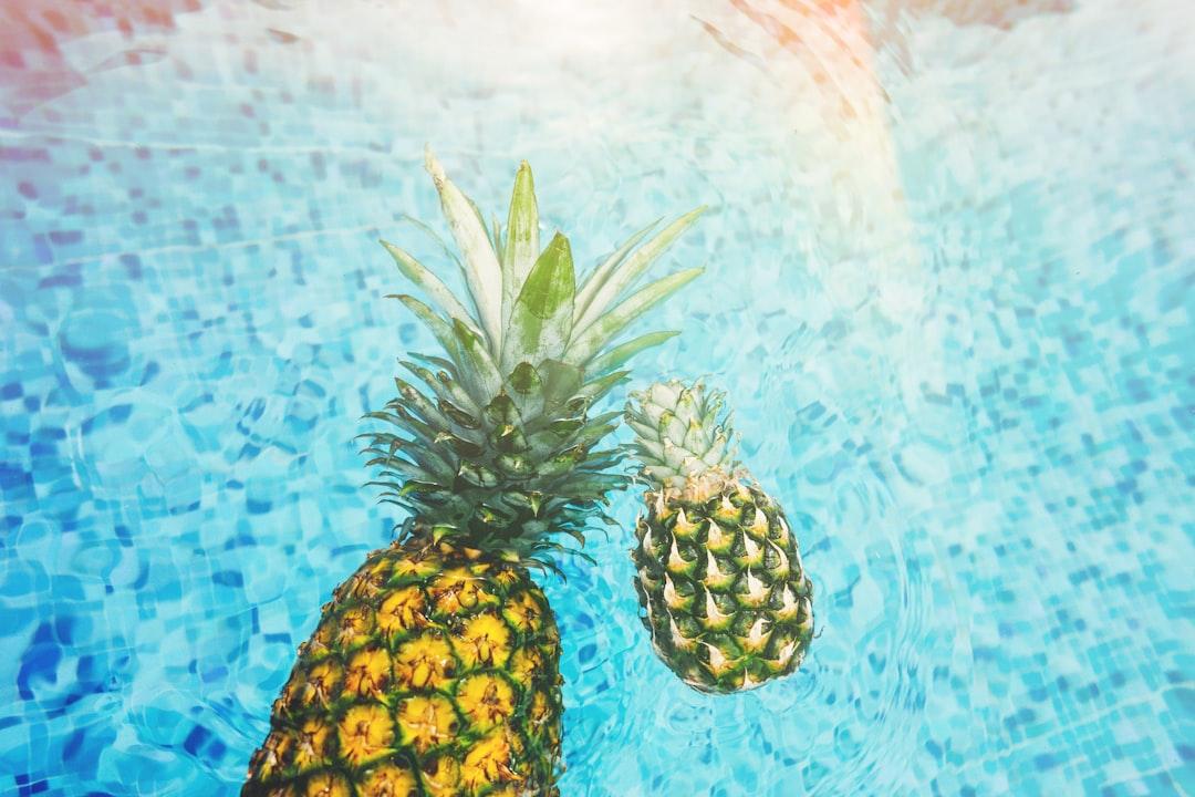 Two pineapples on body of water from Pineapple Supply Co. on Unsplash