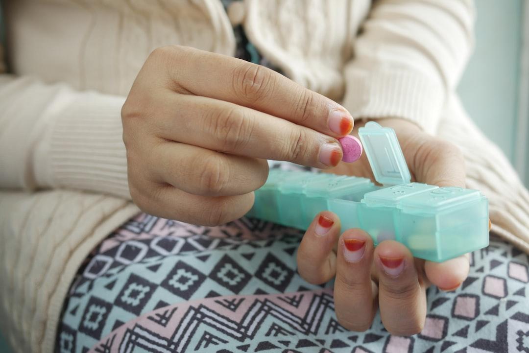person holding white and green plastic container Sốc phản vệ (Anaphylatic)