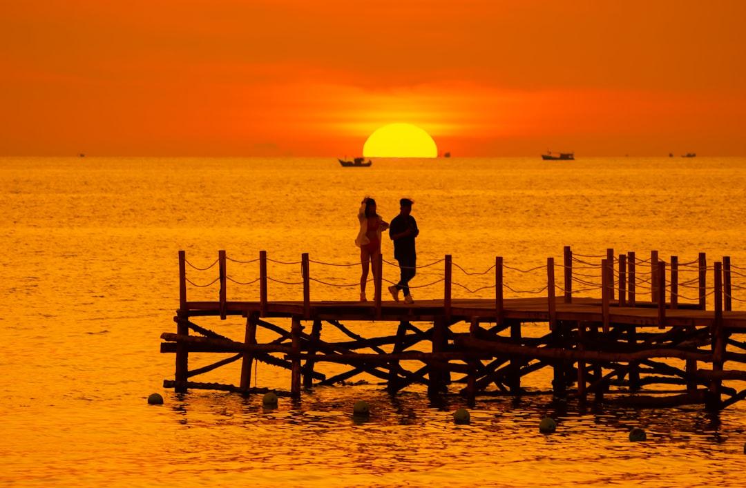 A couple of people standing on top of a wooden pier from Vivu Vietnam on Unsplash Sốt xuất huyết bùng phát tại Kiên Giang