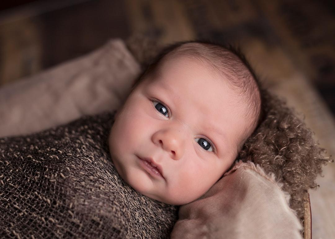 Baby in brown swaddle from Mindy Olson P on Unsplash Tăng cường dinh dưỡng ở phụ nữ mang thai và cho con bú