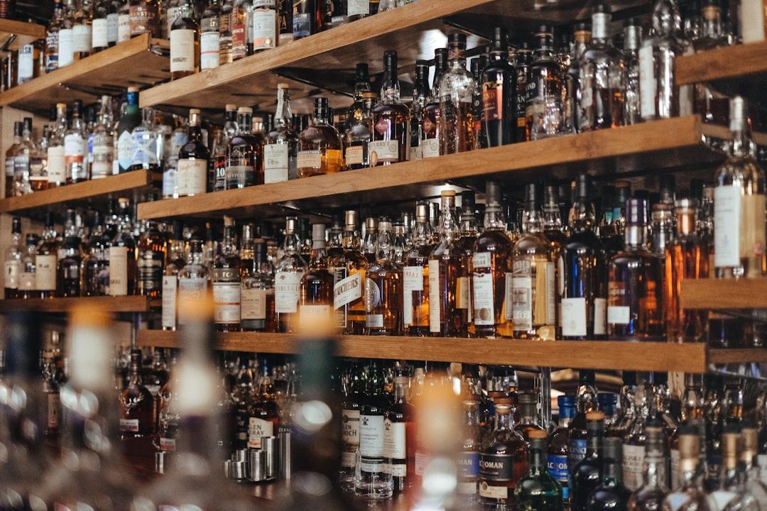 Assorted-color bottle lot on shelf from Adam Wilson on Unsplash Uống rượu, "giết" gan
