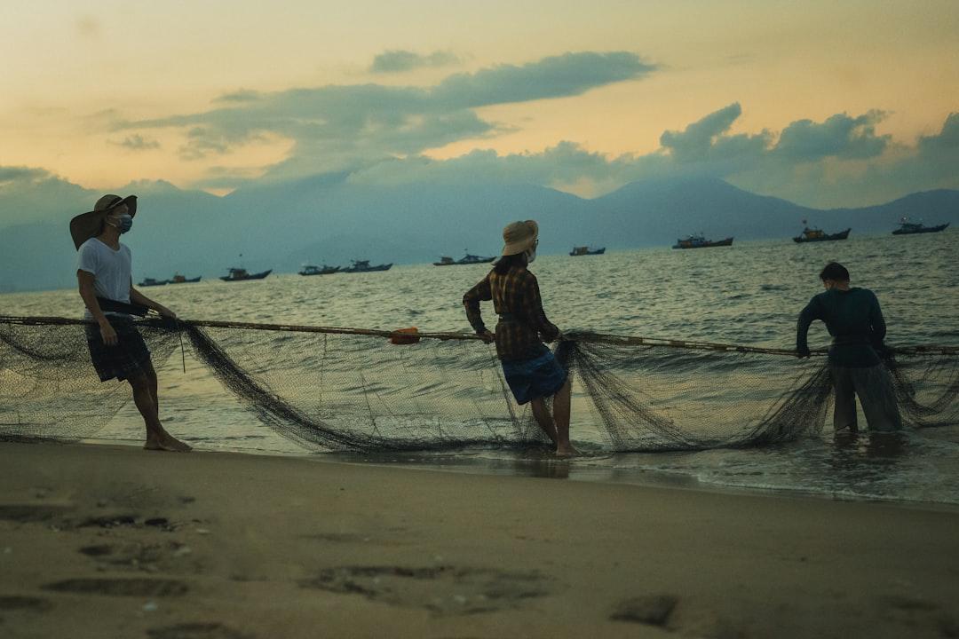 A group of people standing on top of a beach next to the ocean from Leon Thắng on Unsplash Đà Nẵng: Thêm hai ca nhiễm cúm A/H1N1
