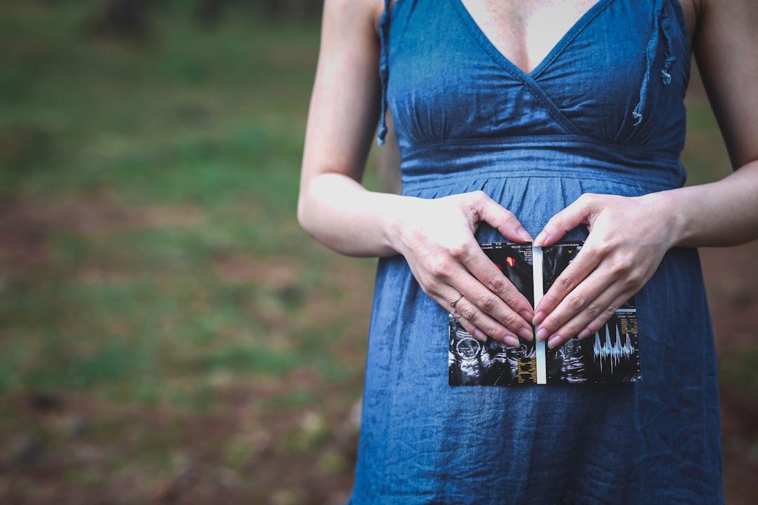 Pregnant woman holding her tummy from Bich Ngoc Le on Unsplash Bà bầu chăm sưởi nắng, xương bé sẽ khỏe