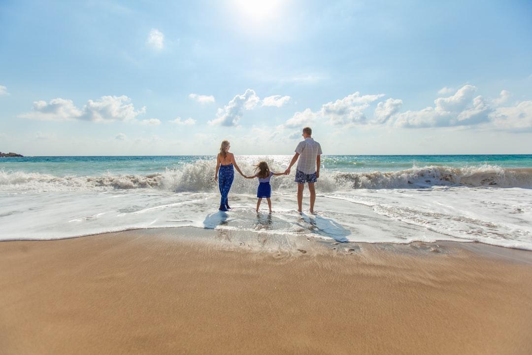 Man, woman and child holding hands on seashore from Natalya Zaritskaya on Unsplash Hai mặt của 'phim người lớn'