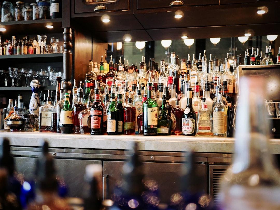 Liquor bottles on white and brown wooden cabinet from Eaters Collective on Unsplash Ngộ độc rượu