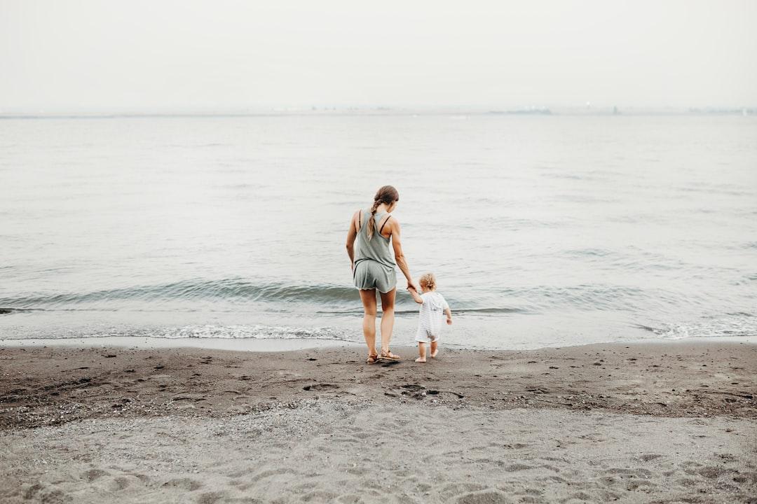 Woman and baby walking on gray sand seashore during daytime from Liana Mikah on Unsplash Lây truyền HIV từ mẹ sang con tăng ở mức nguy hiểm