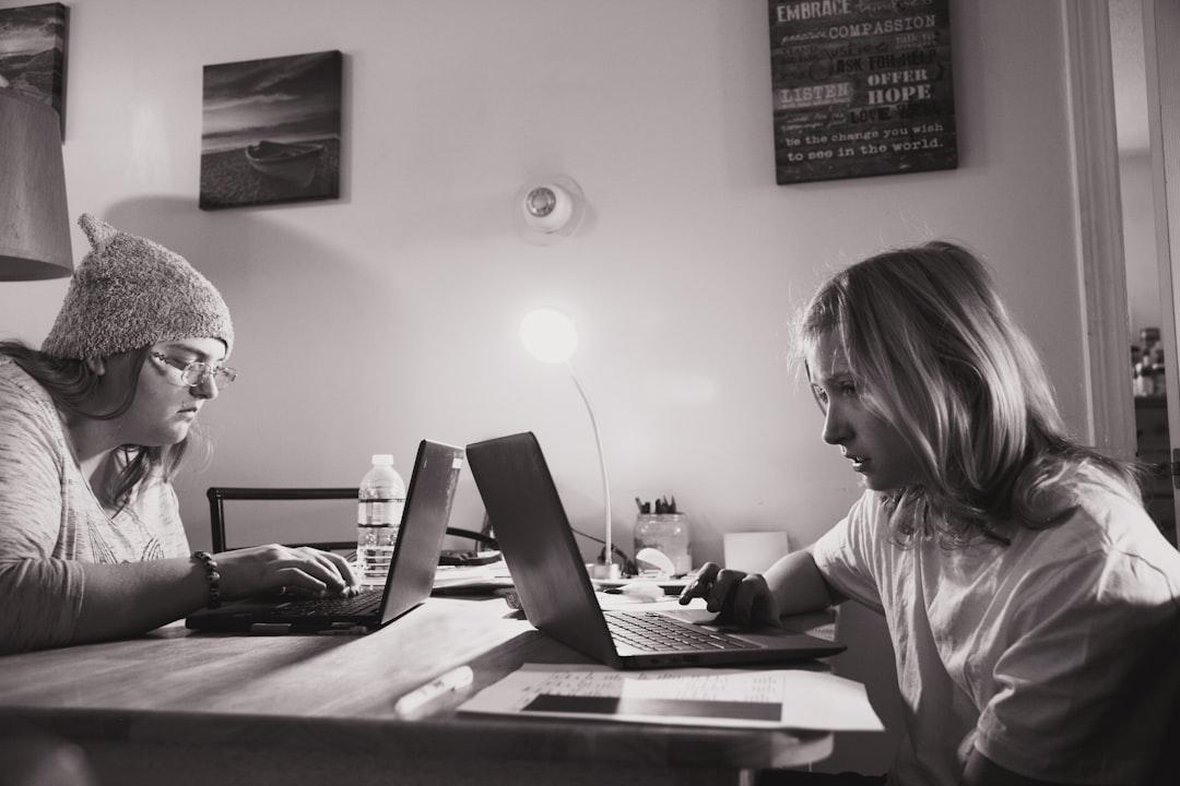 Woman in white and black stripe long sleeve shirt using laptop computer on brown wooden table from Alexander Grey on Unsplash Tin mừng về vacine phòng cúm A/H1N1