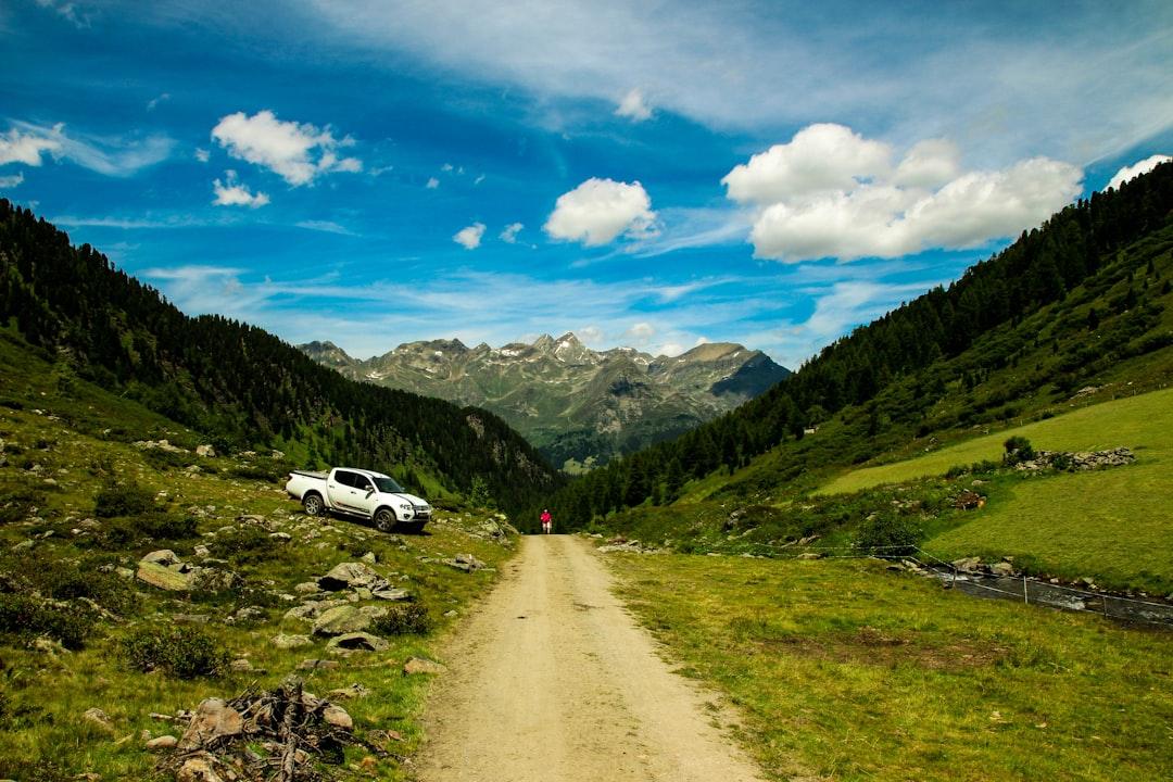 white car on road near green grass field and mountains during daytime Ngực - Bệnh lao