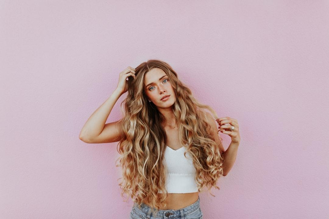 Woman standing next to pink wall while scratching her head from averie woodard on Unsplash Tỷ số giới tính nam/nữ khi sinh tăng bất thường