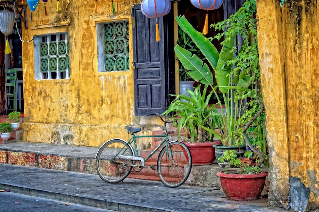 Green bicycle parked beside yellow concrete house at daytime from Steve Douglas on Unsplash