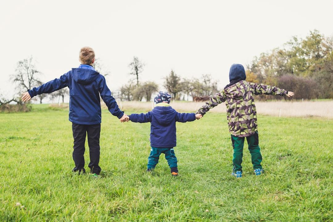 three children holding hands standing on grasses Bụng - Viêm gan do virút