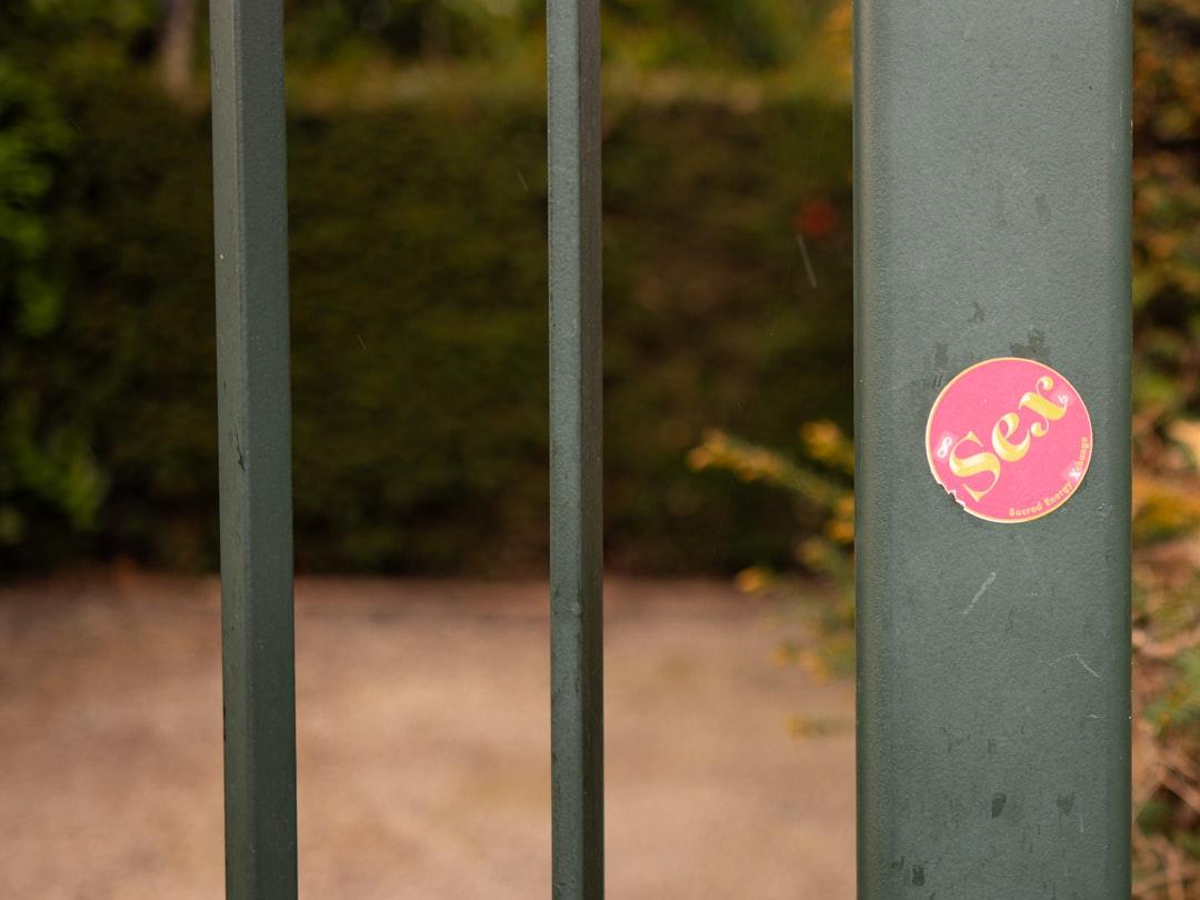 Red and yellow heart sticker on gray metal fence from the blowup on Unsplash