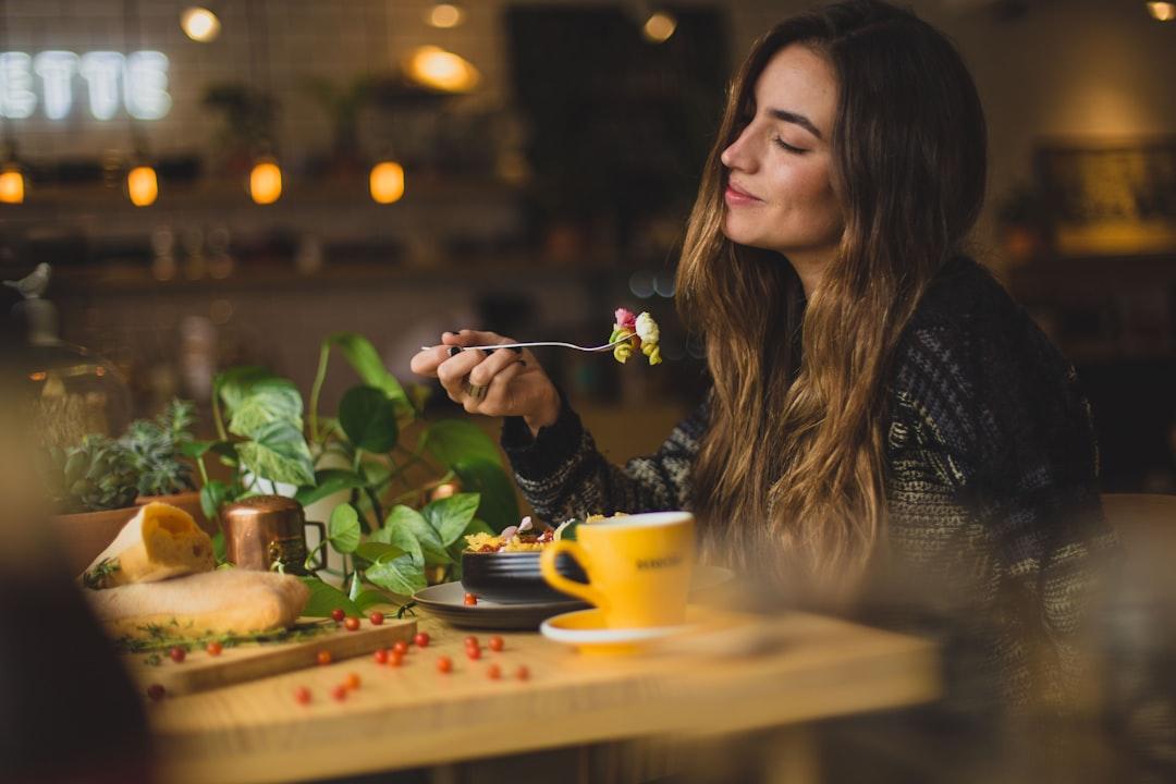 Woman holding fork in front table from Pablo Merchán Montes on Unsplash