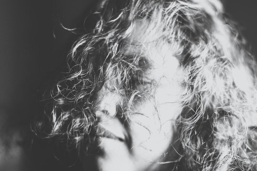 Grayscale photography of a woman's face covered with her hair from Hermes Rivera on Unsplash