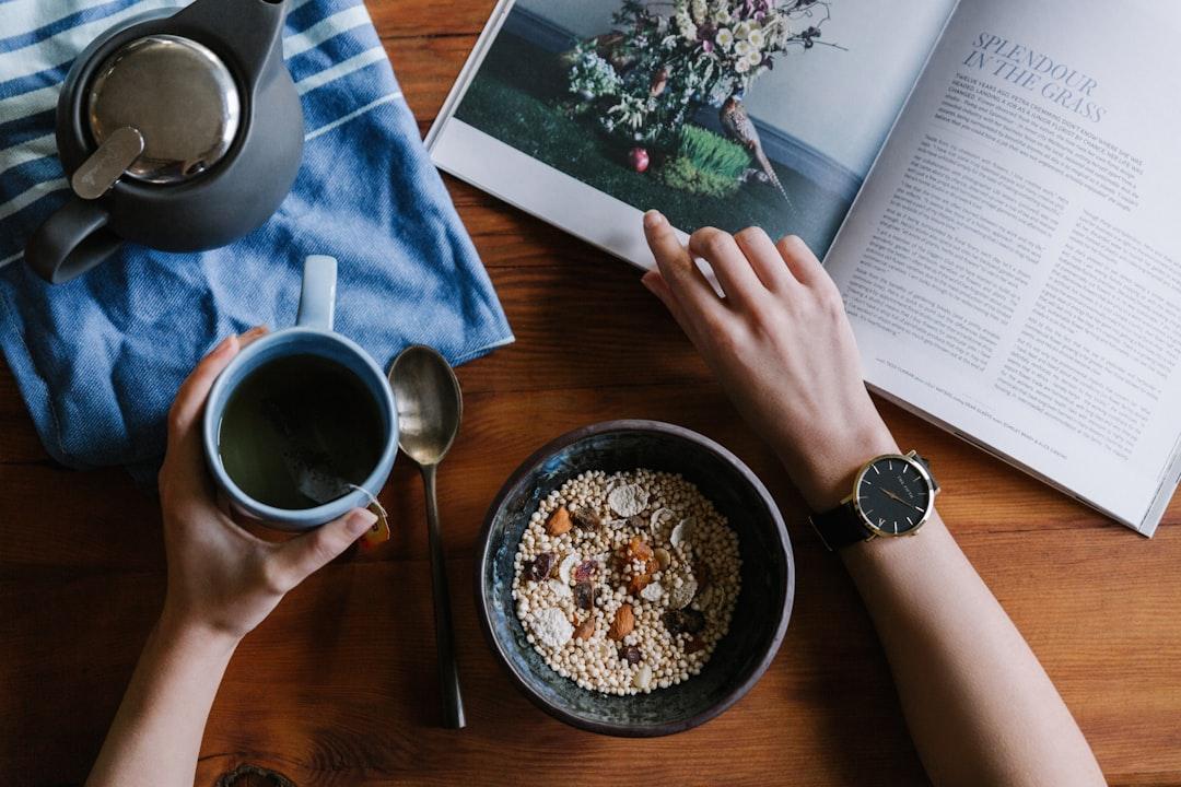 Person holding blue ceramic mug and white magazine from THE 5TH on Unsplash