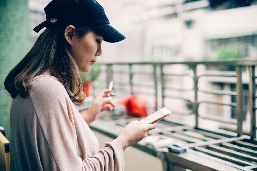 Woman looking at phone from Andrew Leu on Unsplash