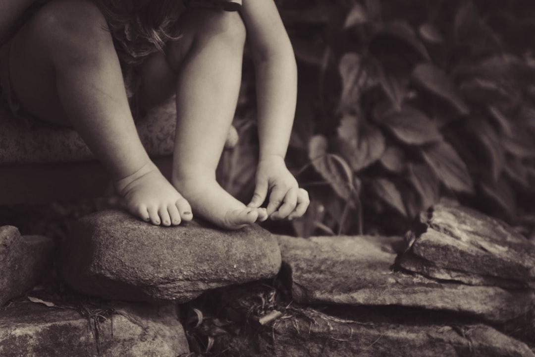 Depth photography of child sitting on rock beside plant from Gabby Orcutt on Unsplash Tiêu hủy đàn bò sữa lở mồm long móng