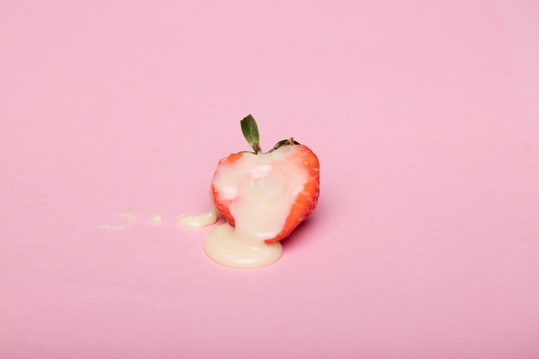 Red cherry fruit on pink surface from Deon Black on Unsplash