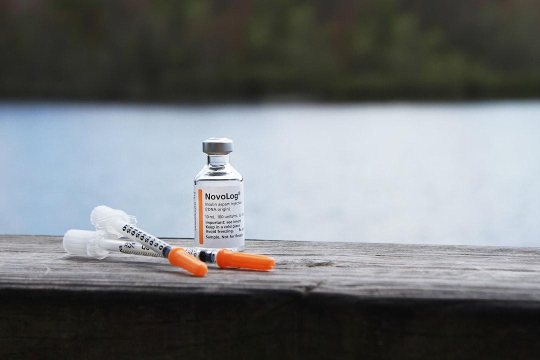 Orange and white plastic bottle on brown wooden table from Mykenzie Johnson on Unsplash
