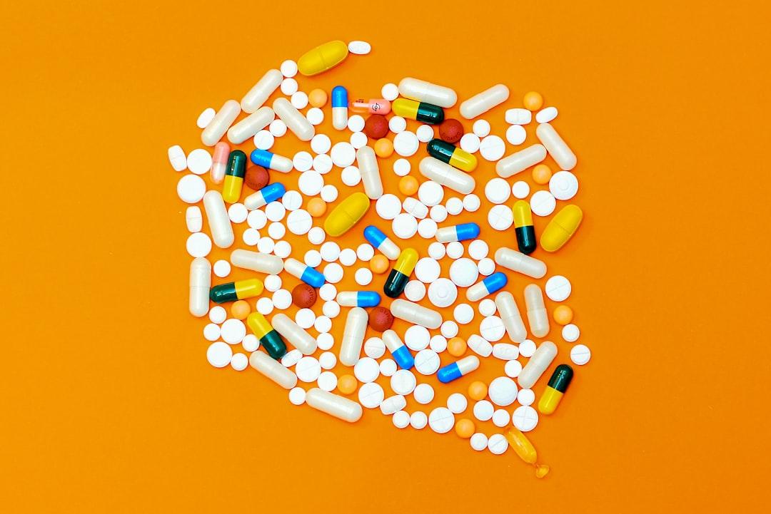 White and orange medication pill from Michał Parzuchowski on Unsplash