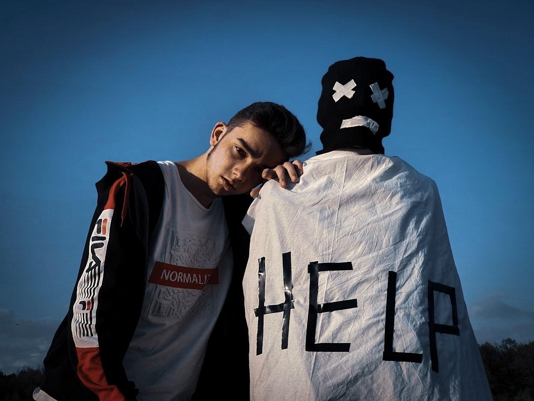 Man in white and black jacket beside man in white and black crew neck shirt under from Iluha Zavaley on Unsplash