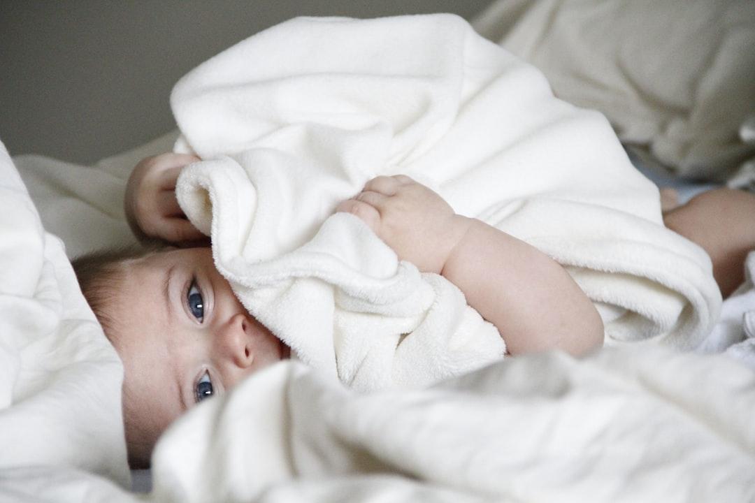 Baby laying on bed from Michal Bar Haim on Unsplash 81,6% trẻ em bị sâu răng sữa
