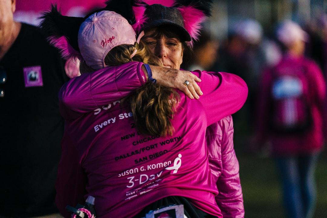 A woman in a pink shirt hugging another woman from Susan G. Komen 3-Day on Unsplash 5 điều nàng… muốn