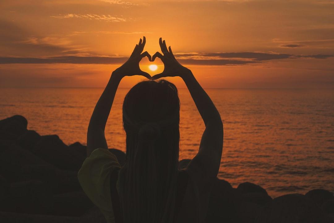 Silhouette of woman doing heart sign during sunset from Aziz Acharki on Unsplash