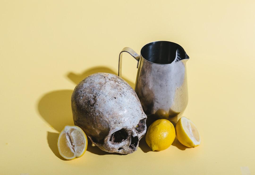 Human skull beside pitcher and lemons from Florencia Potter on Unsplash